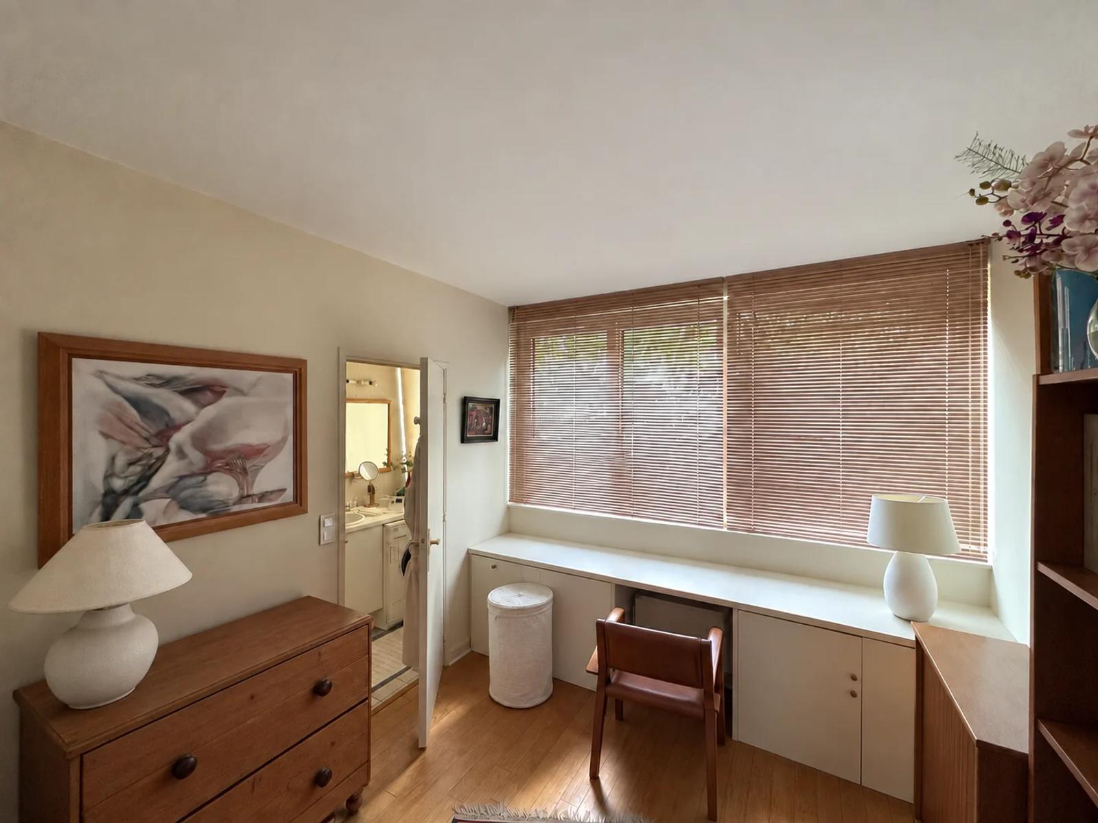 Pièce aménagée en bureau avec rangements sous la fenêtre — La Celle-Saint-Cloud.