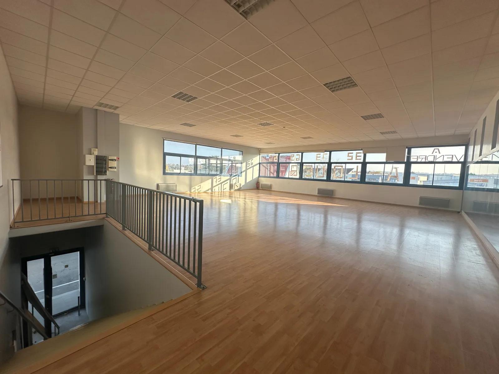 Grande salle avec parquet, fenêtres et escalier intérieur — Orgeval.