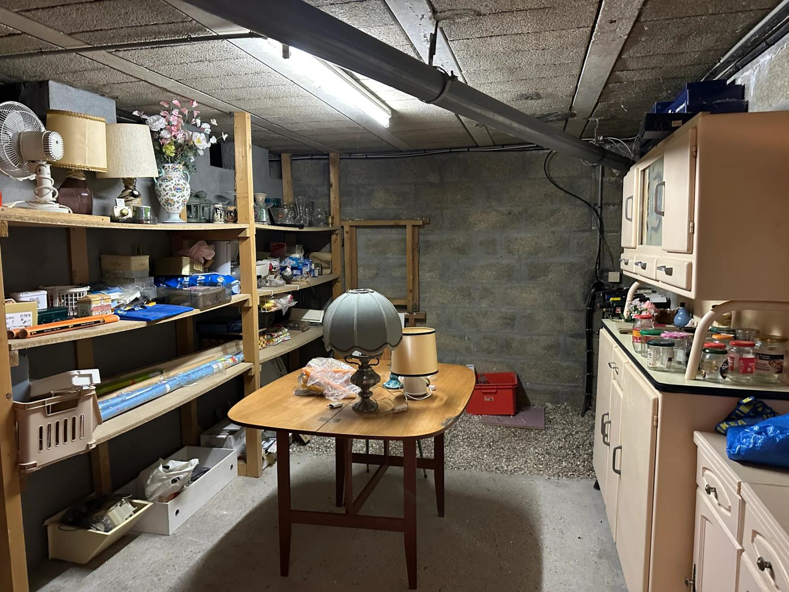 Pièce de rangement en sous-sol avec étagères et table — Maule.