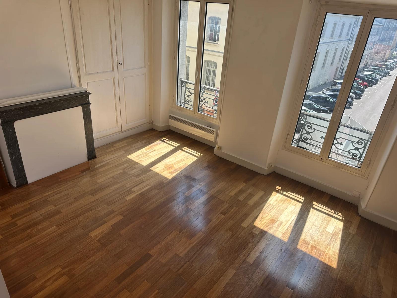 Pièce avec parquet et deux fenêtres donnant sur la rue — Versailles.