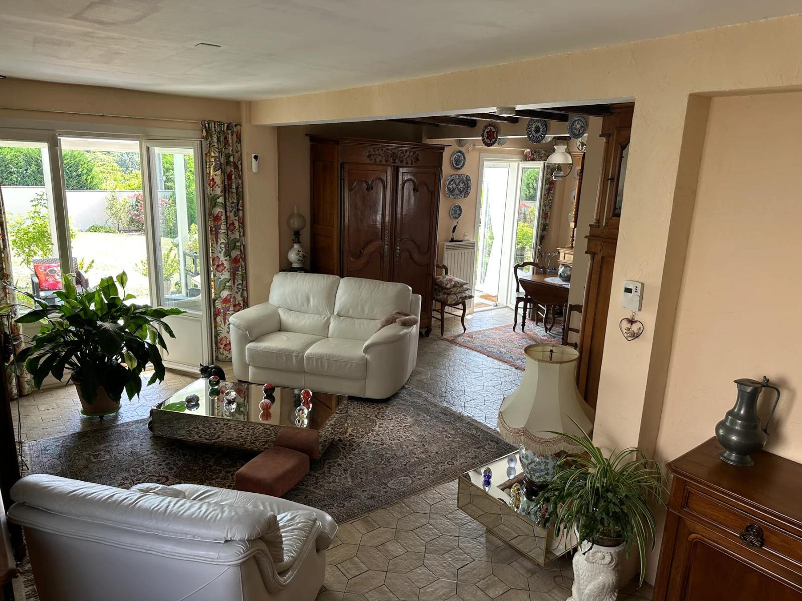 Salon avec canapés clairs et baie vitrée donnant sur la véranda — Maule.