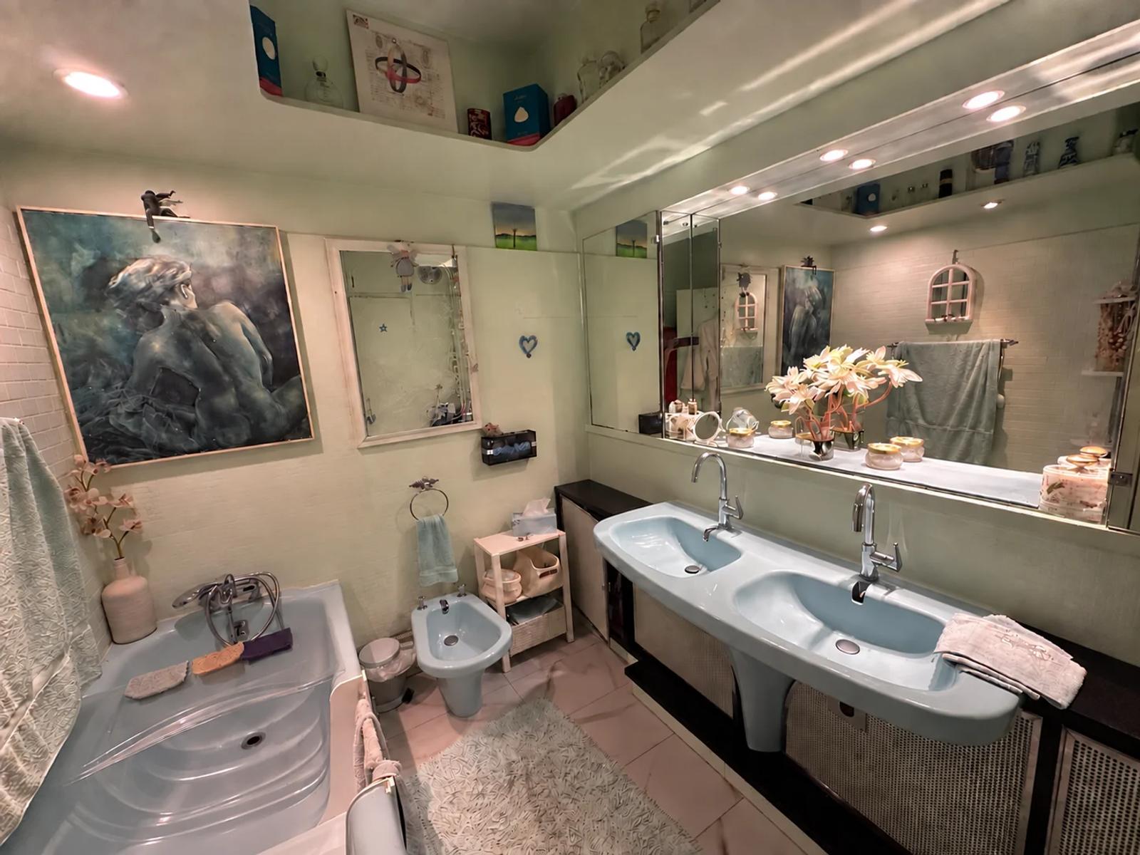 Salle de bains avec baignoire, double vasque et grand miroir — La Celle-Saint-Cloud.