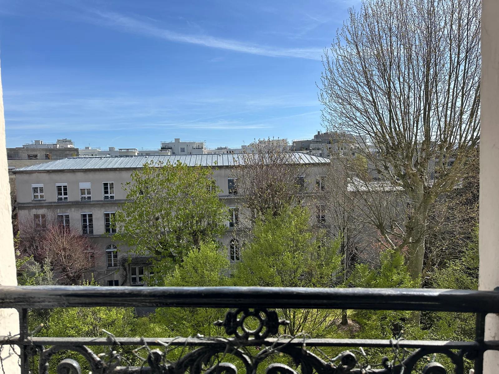 Vue depuis le balcon sur les arbres et les immeubles voisins — Paris 14e.