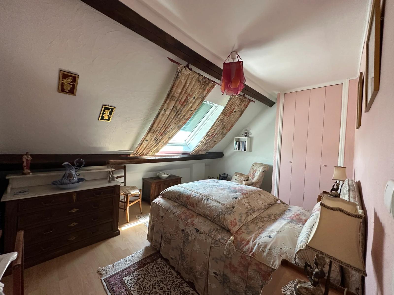 Chambre sous combles avec poutres apparentes et fenêtre de toit — Maule.
