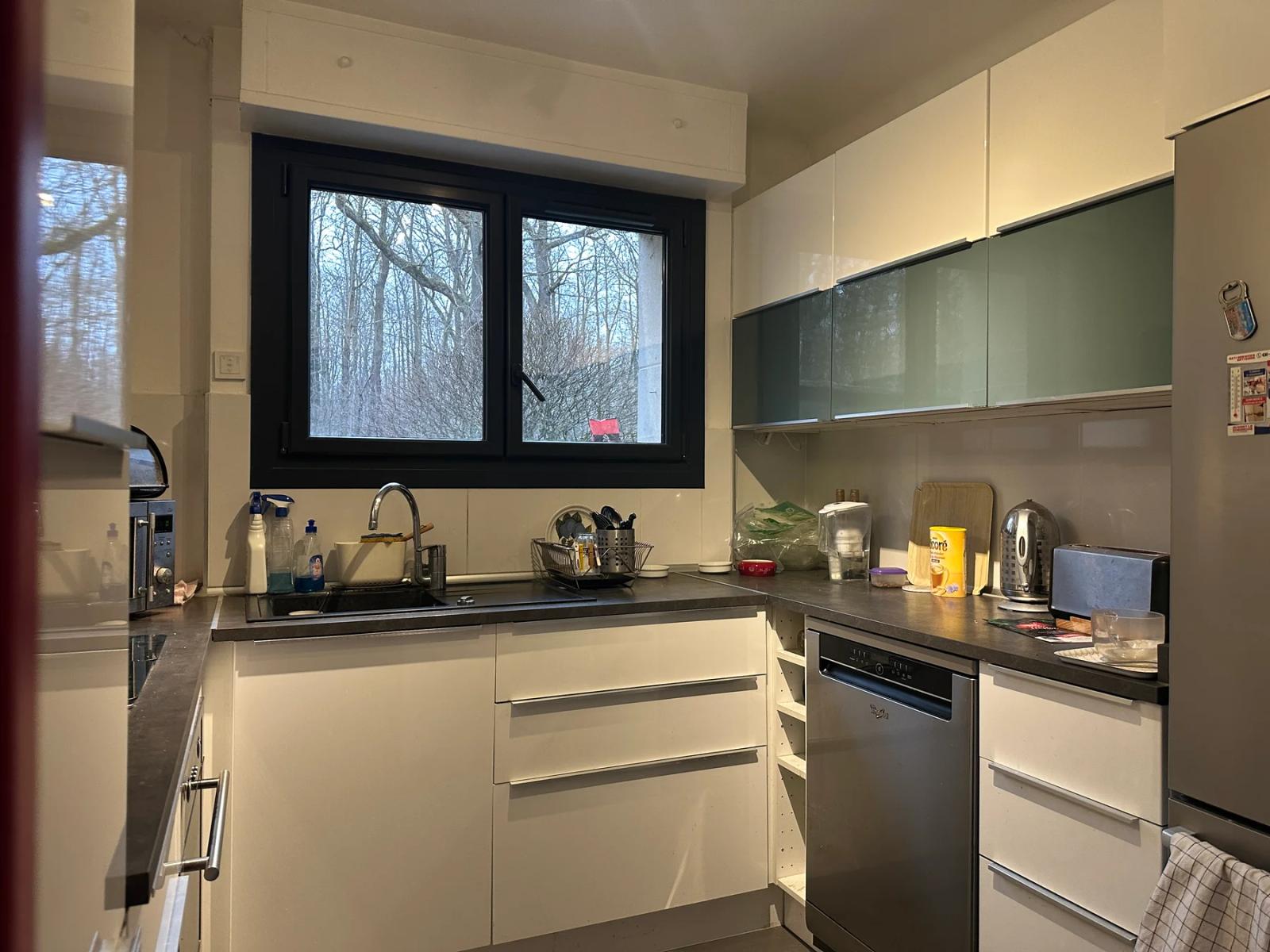 Cuisine équipée avec meubles blancs et fenêtre — Ville-d’Avray.