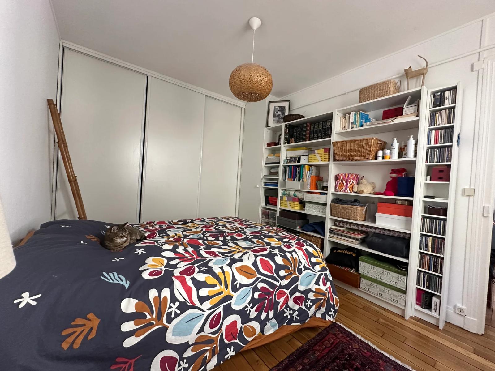 Chambre avec lit double, placards blancs et bibliothèque murale — Paris 11e.