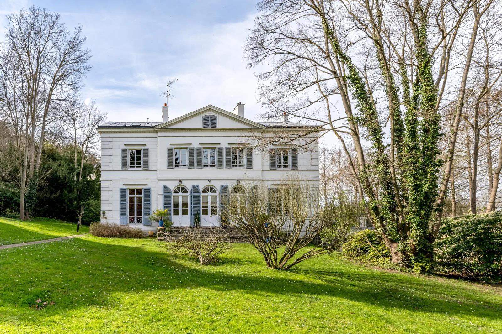 Façade de la demeure avec volets gris, terrasse et pelouse arborée — Bougival.