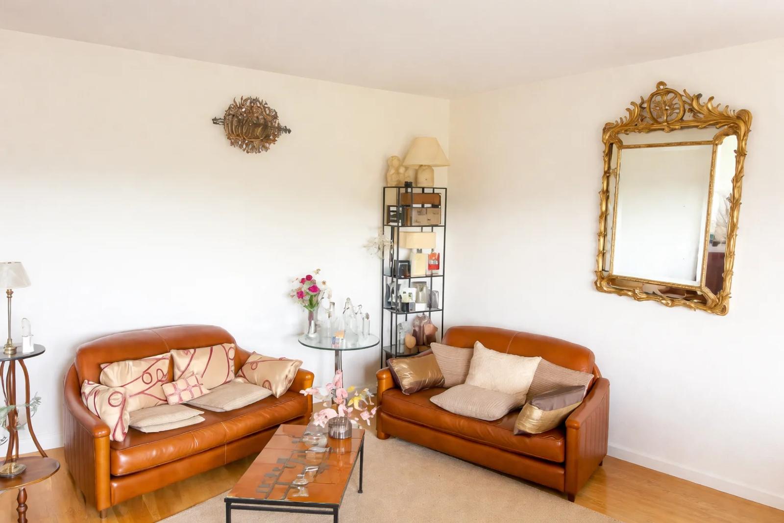 Salon avec canapés en cuir et miroir doré — Croissy-sur-Seine.