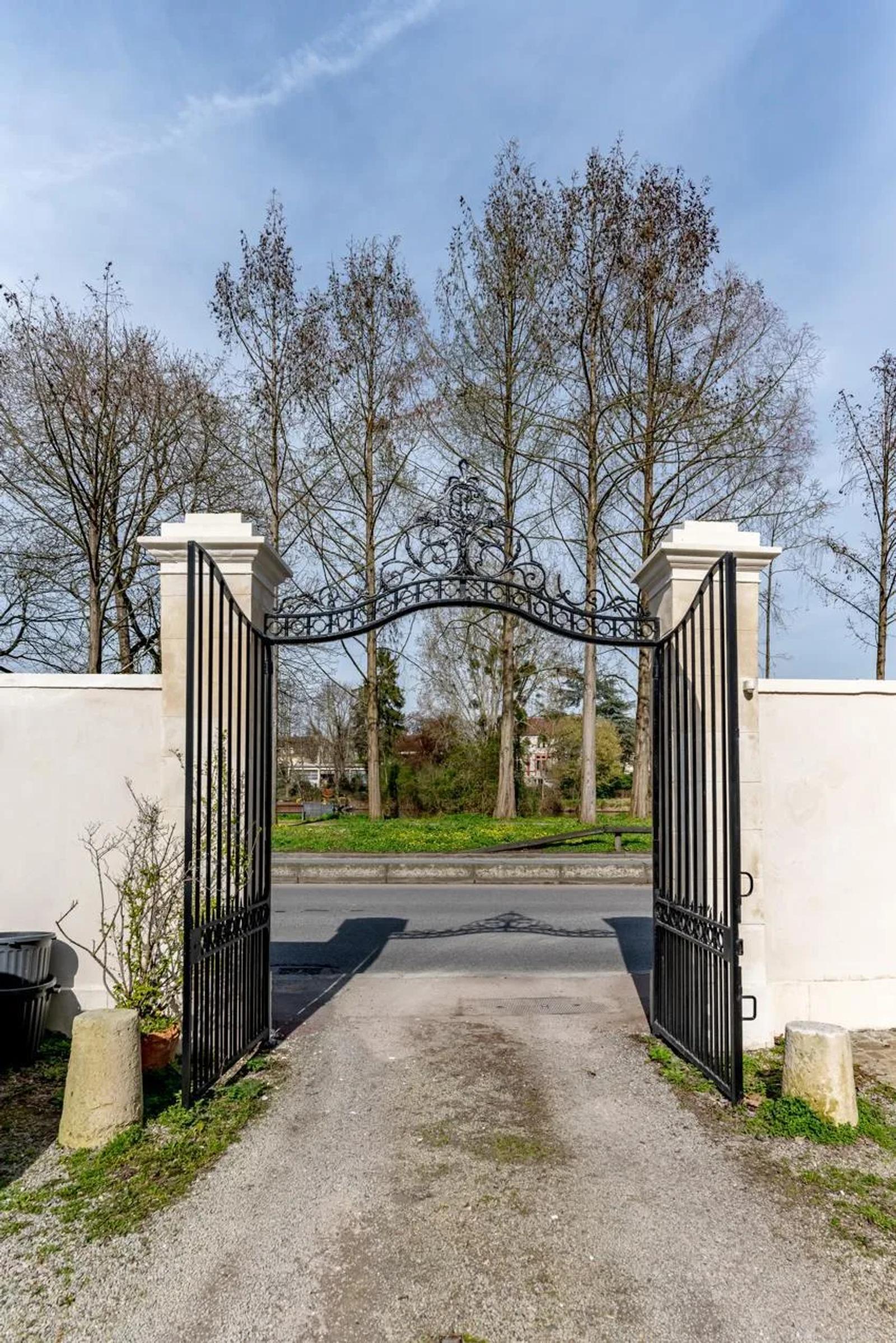Portail en fer ouvrant sur une allée arborée — Bougival.