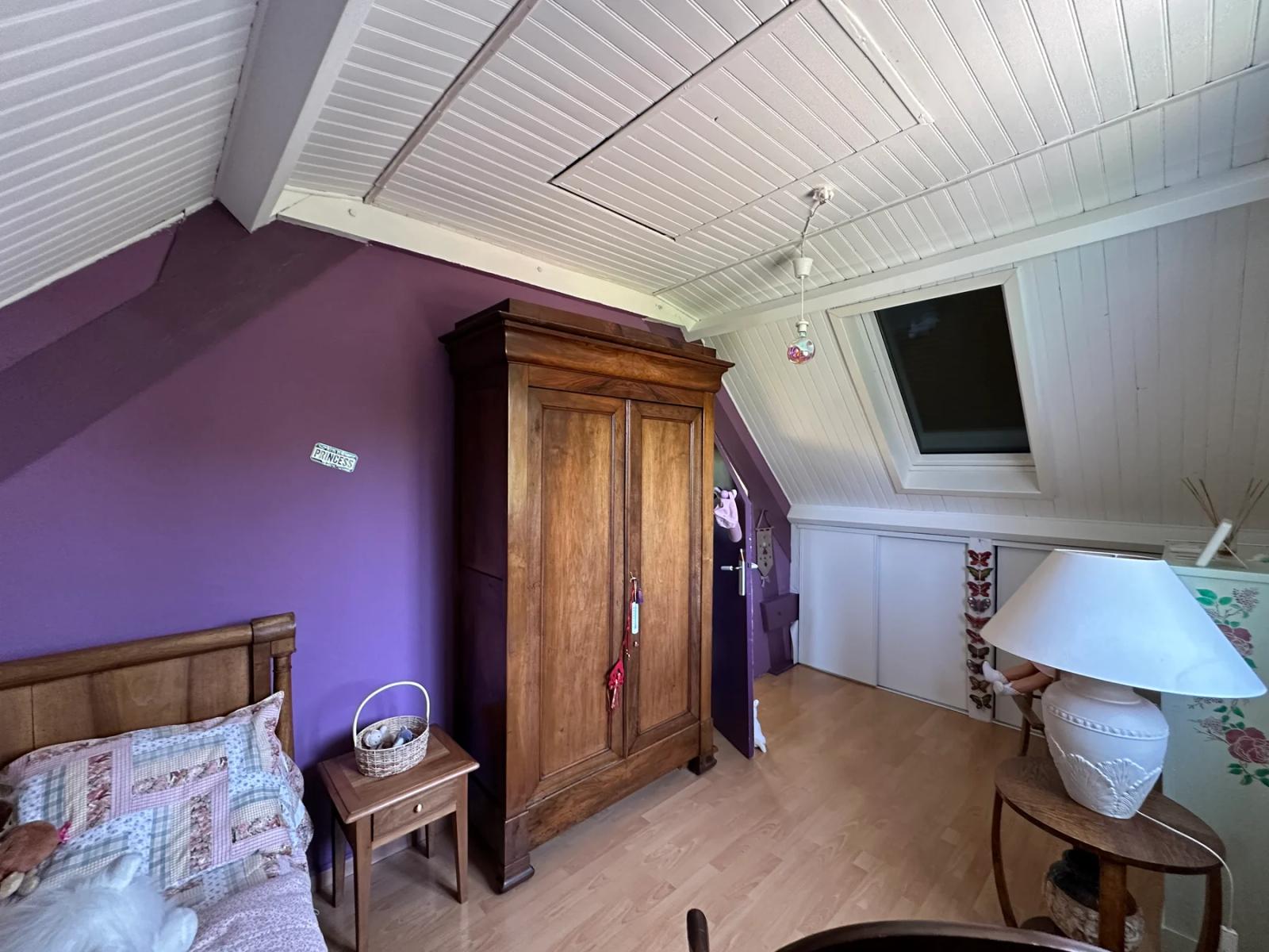 Chambre mansardée aux murs violets avec bureau et armoire — Maule.
