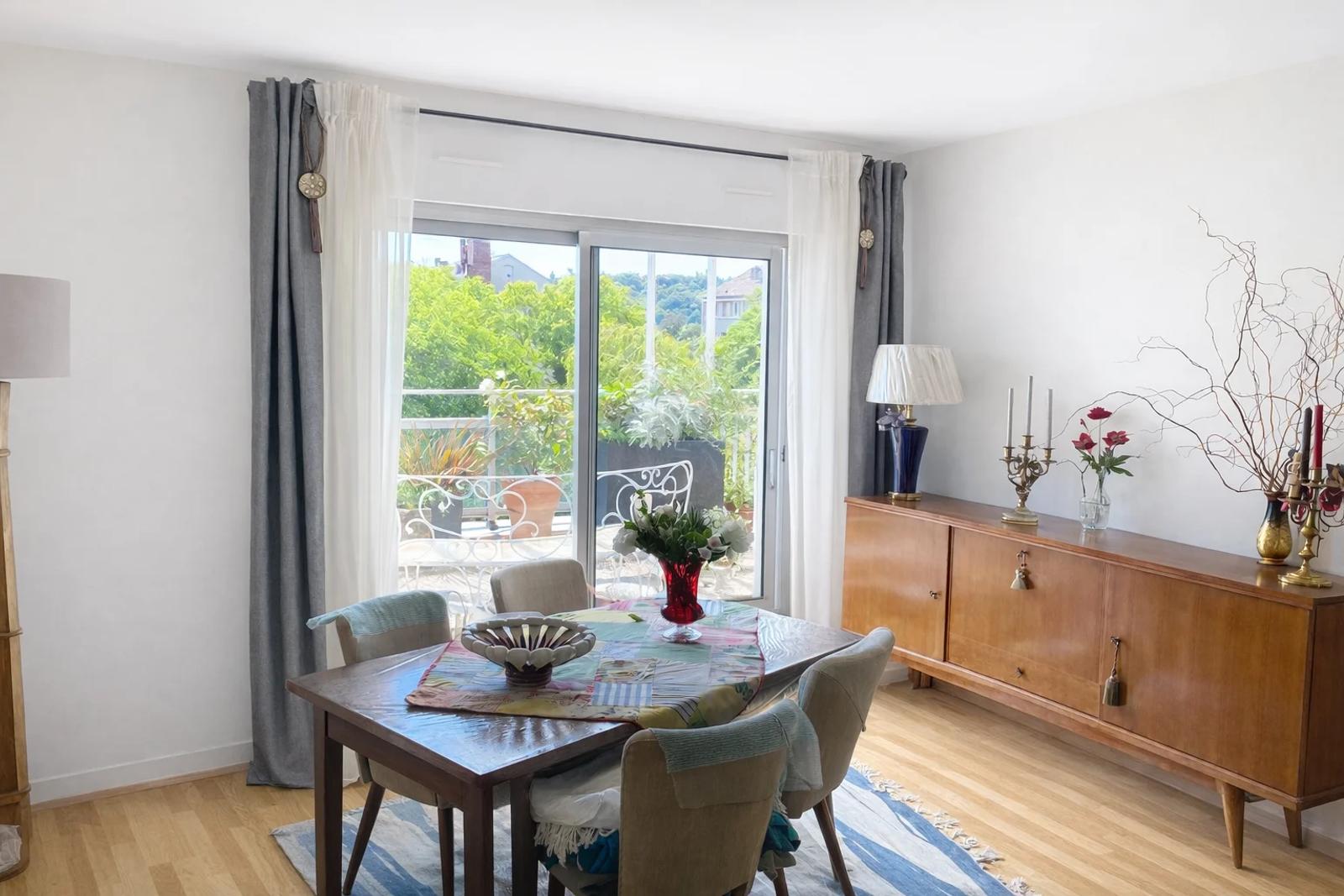 Salle à manger avec parquet et baie vitrée donnant sur la terrasse — Croissy-sur-Seine.