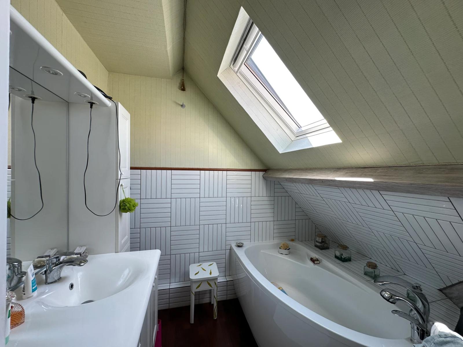 Salle de bains sous pente avec baignoire d’angle et fenêtre de toit — Maule.
