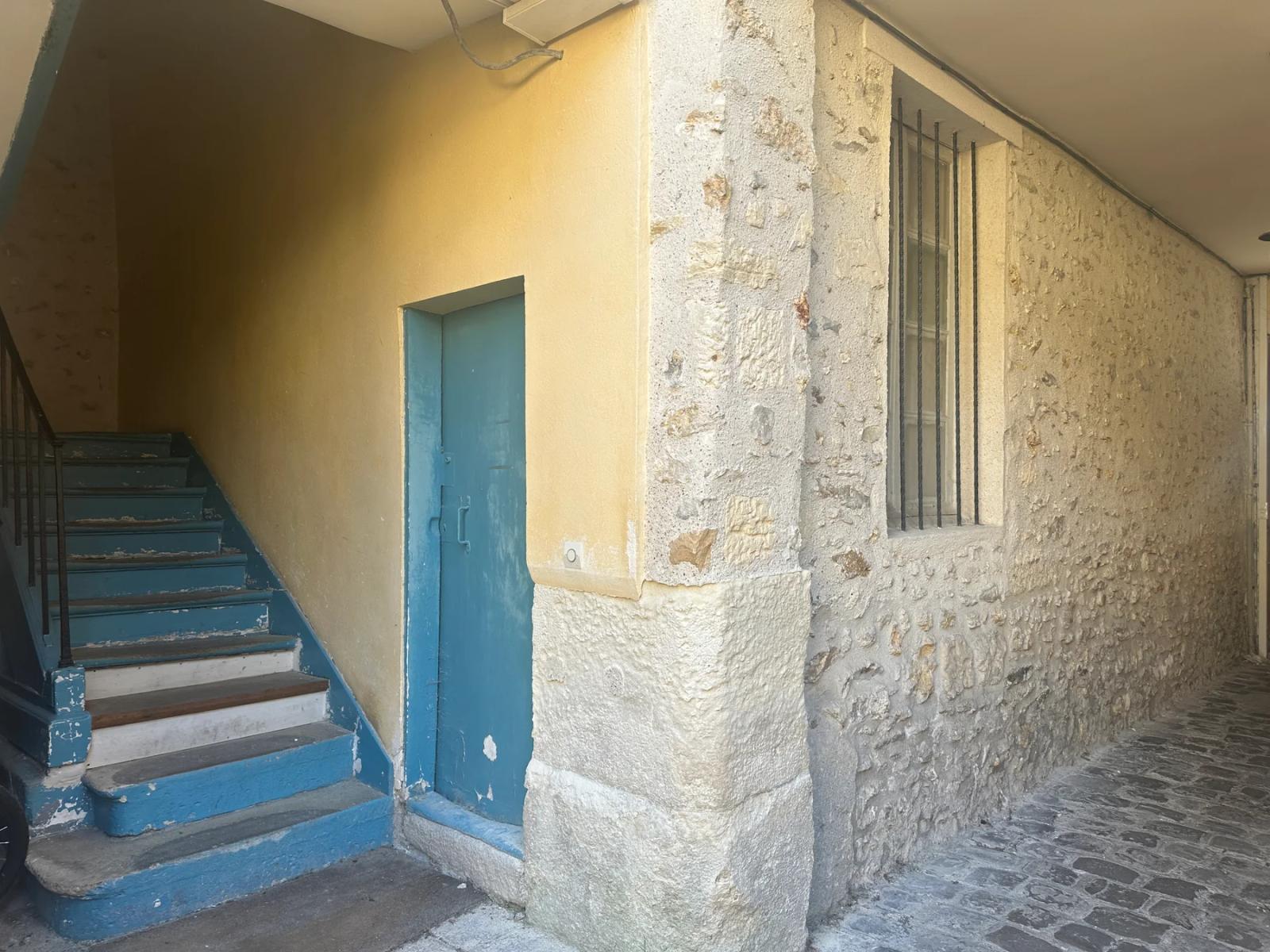 Escalier des parties communes avec mur en pierre apparente — Versailles.