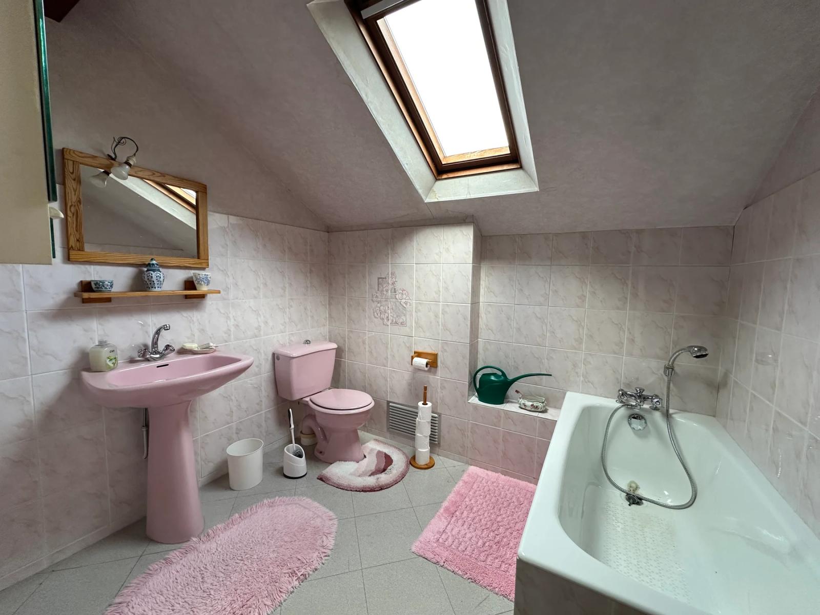 Salle de bains mansardée avec baignoire, lavabo et toilettes — Les Clayes-sous-Bois.