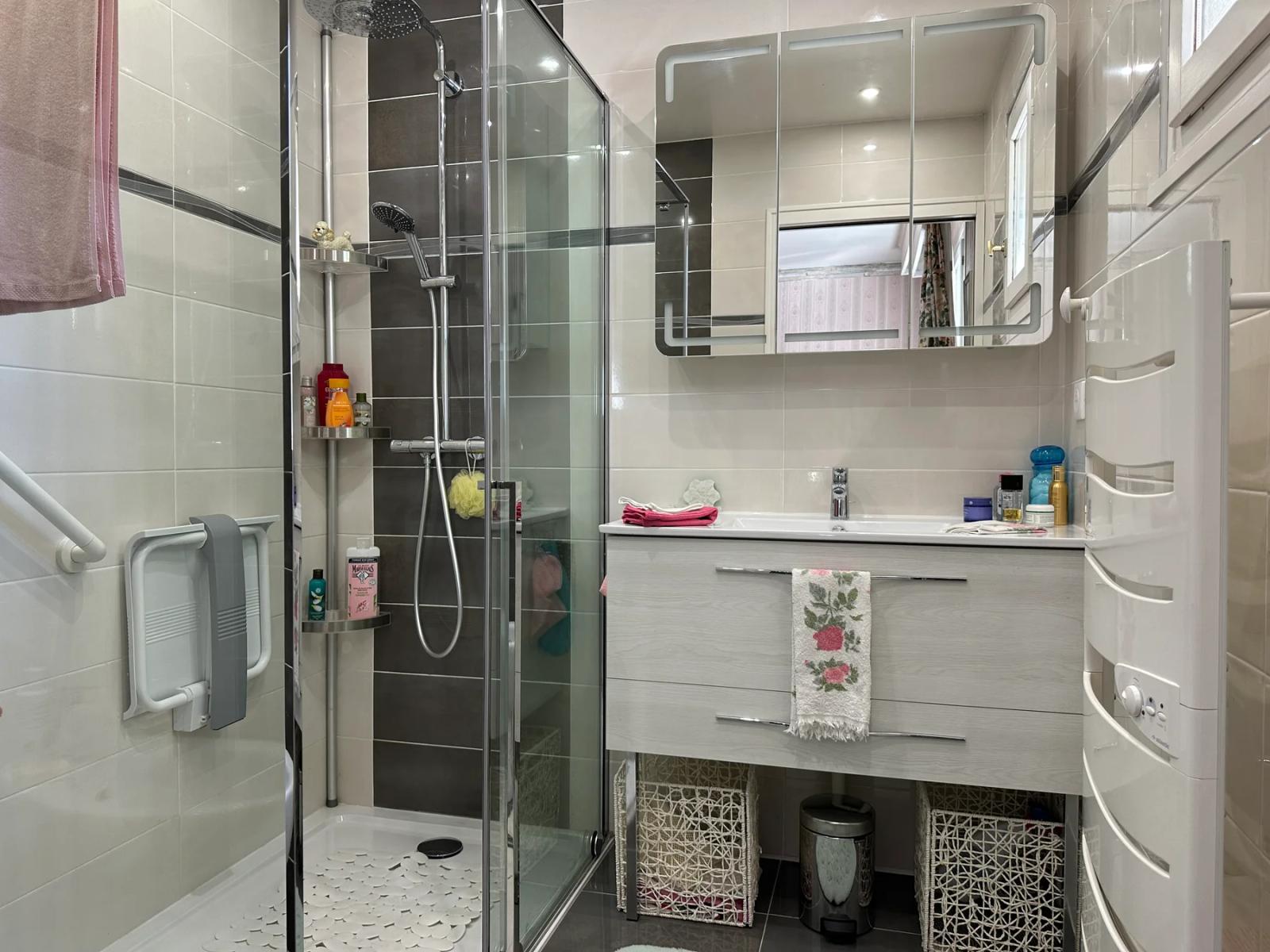 Salle d’eau avec douche vitrée et meuble vasque blanc — Maule.