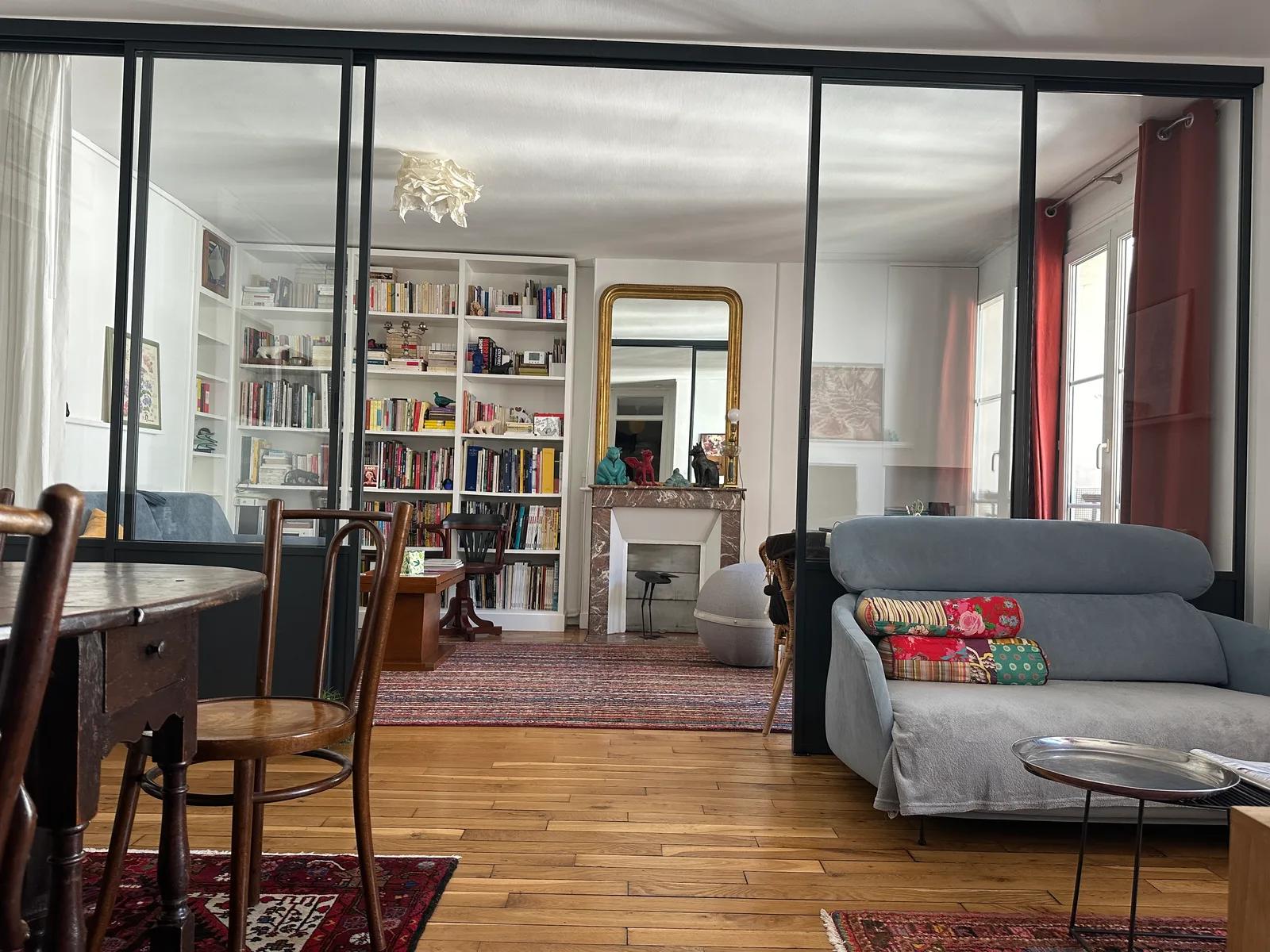 Verrière intérieure entre le coin repas et le salon avec cheminée et bibliothèque — Paris 11e.