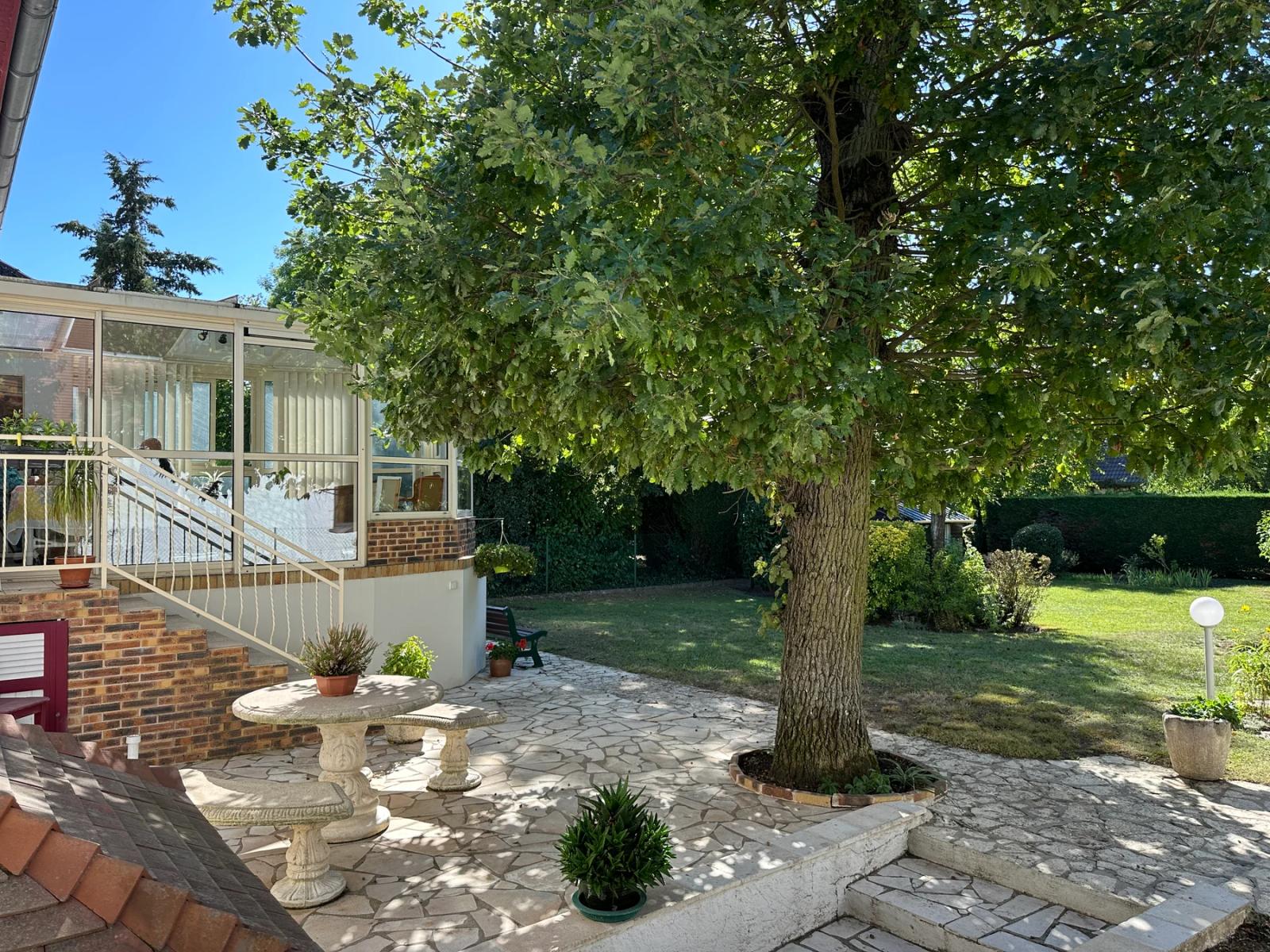 Terrasse dallée devant la véranda et jardin arboré — Maule.