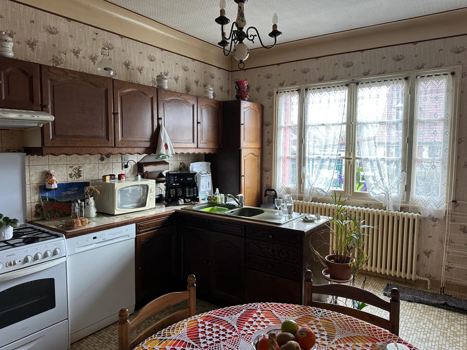 Cuisine avec meubles en bois, table et fenêtre — Les Clayes-sous-Bois.
