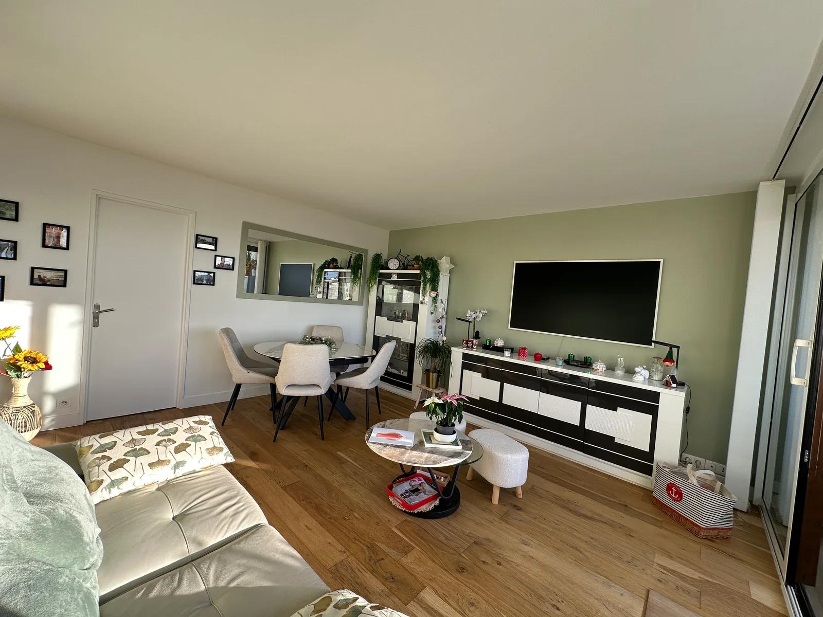 Séjour avec parquet, coin repas et mur vert — Meudon-la-Forêt.