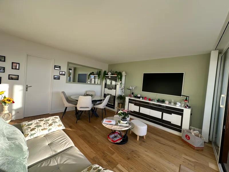 Séjour avec parquet, coin repas et mur vert — Meudon-la-Forêt.