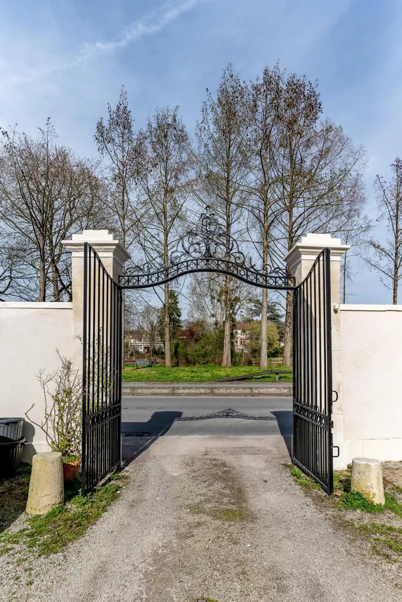 Portail en fer ouvrant sur une allée arborée — Bougival.