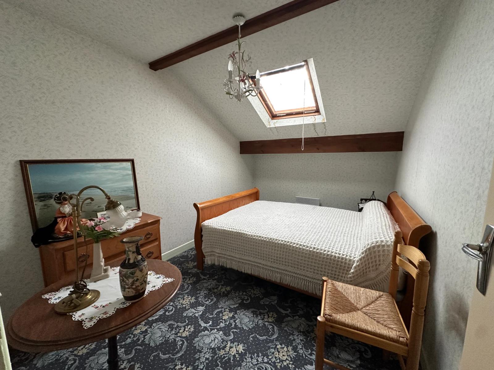 Chambre mansardée avec lit et fenêtre de toit — Les Clayes-sous-Bois.