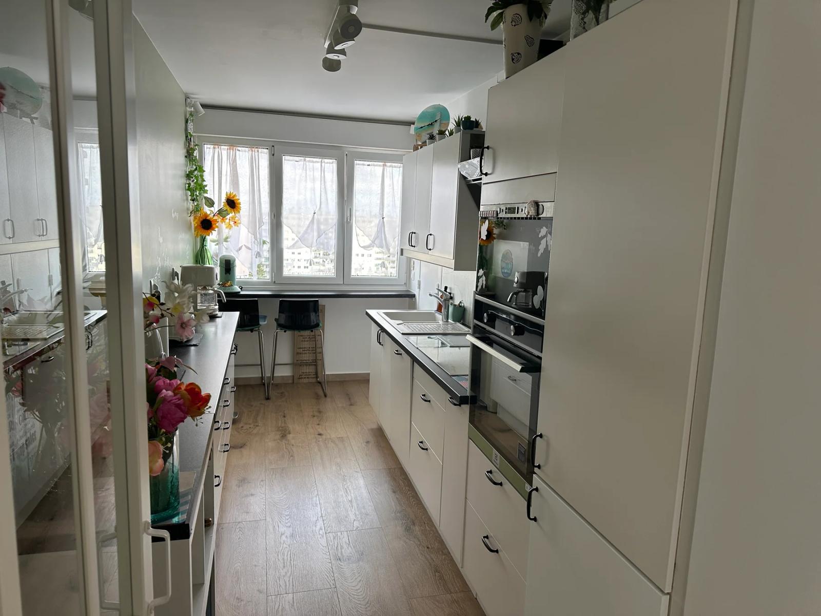 Cuisine blanche équipée avec fenêtre et rangements en hauteur — Meudon-la-Forêt.