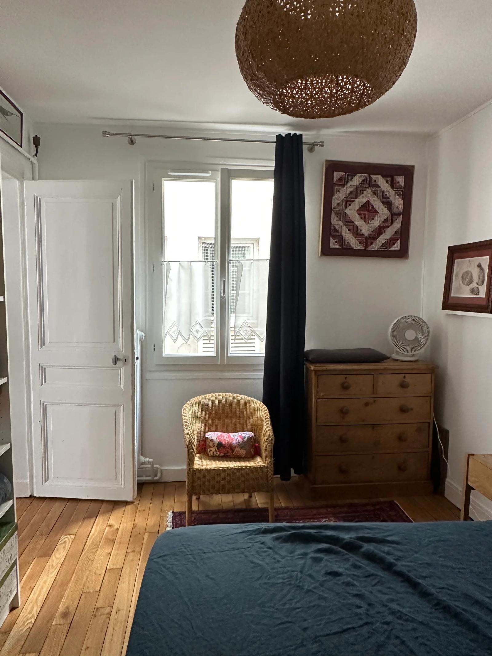 Chambre avec parquet, commode et porte-fenêtre — Paris 11e.