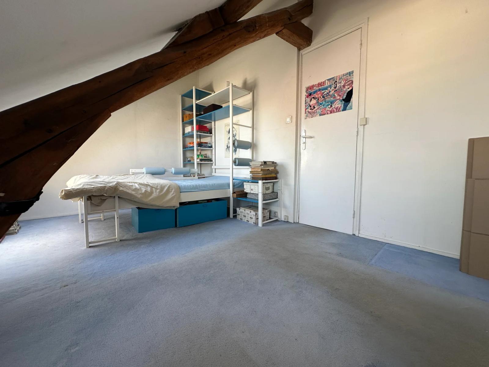 Chambre sous combles avec poutre apparente et placard miroir — Versailles.