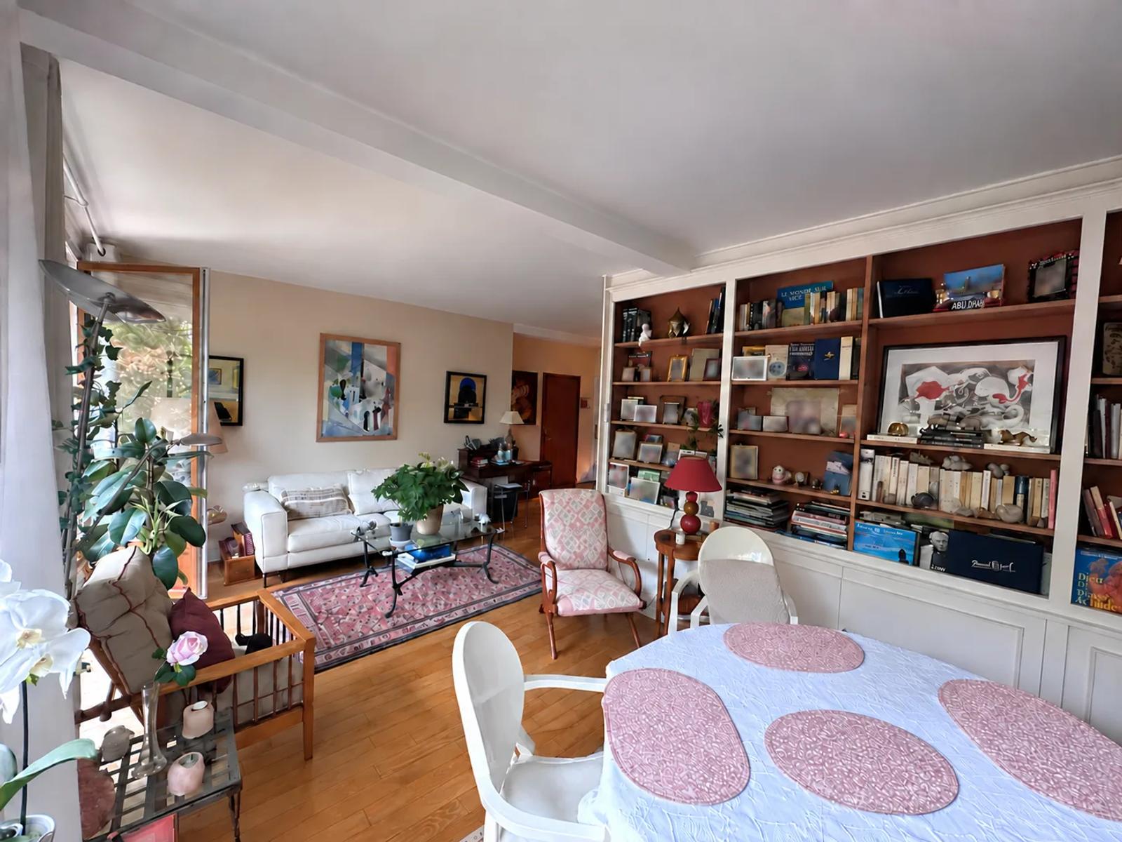Séjour traversant avec canapé, coin repas et bibliothèque murale — La Celle-Saint-Cloud.
