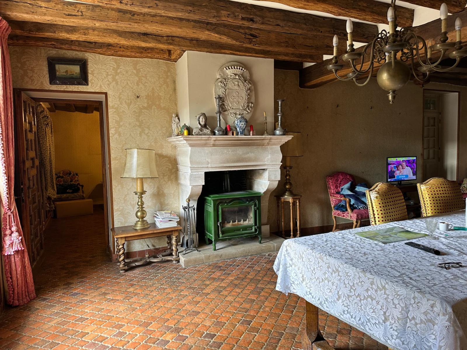 Salle à manger avec cheminée, poutres et sol en terre cuite — Villeconin.