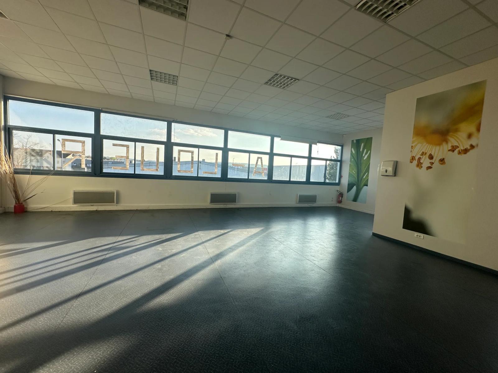 Salle d’activité au sol sombre éclairée par une rangée de fenêtres — Orgeval.
