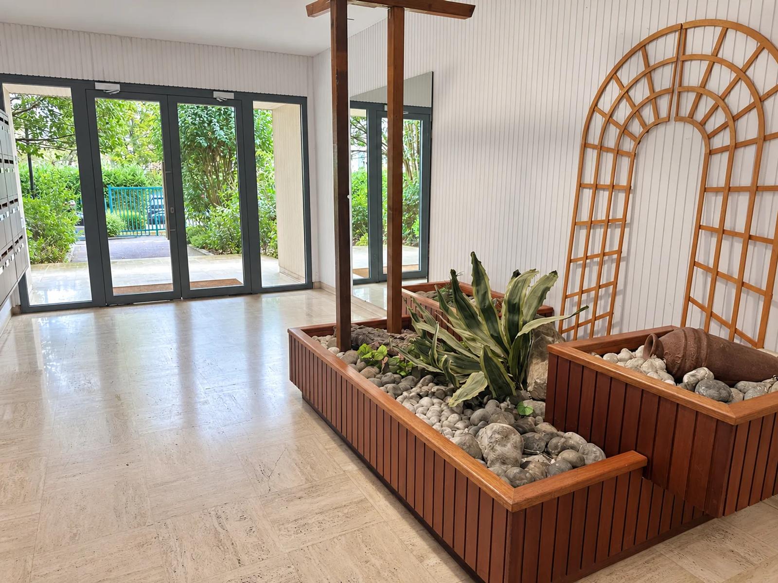 Hall de la résidence avec jardinière intérieure et portes vitrées — Carrières-sur-Seine.