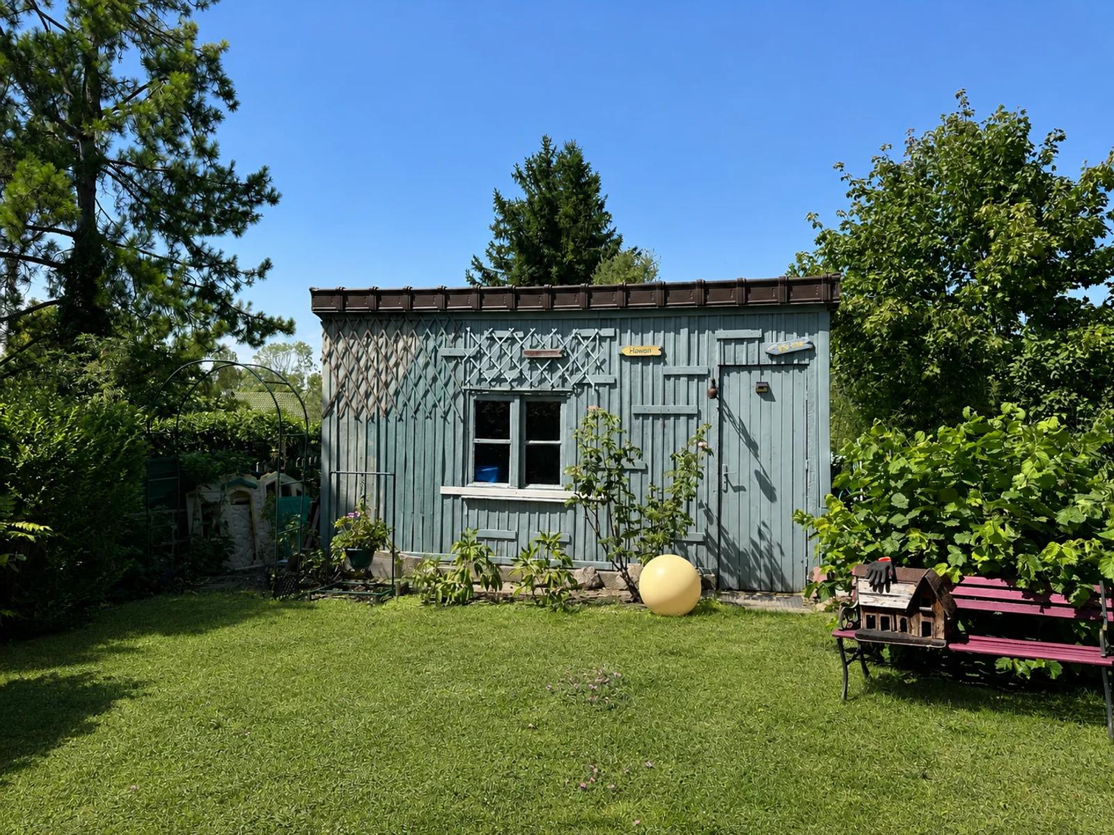 Abri de jardin en bois gris devant la pelouse — Maule.