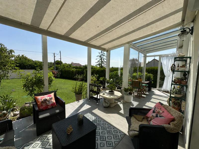 Véranda avec coin salon et grandes baies vitrées sur le jardin — Maule.