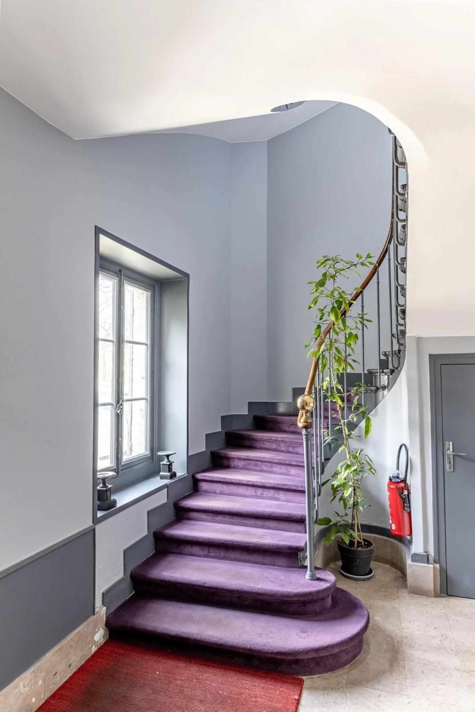Escalier courbe avec rampe en fer forgé dans les parties communes — Bougival.