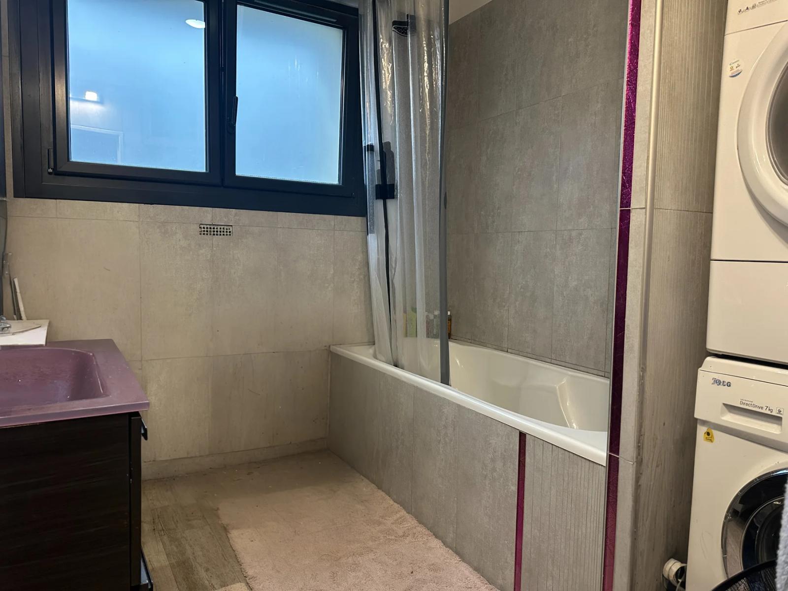Salle de bains avec baignoire, pare-baignoire et fenêtre — Ville-d’Avray.