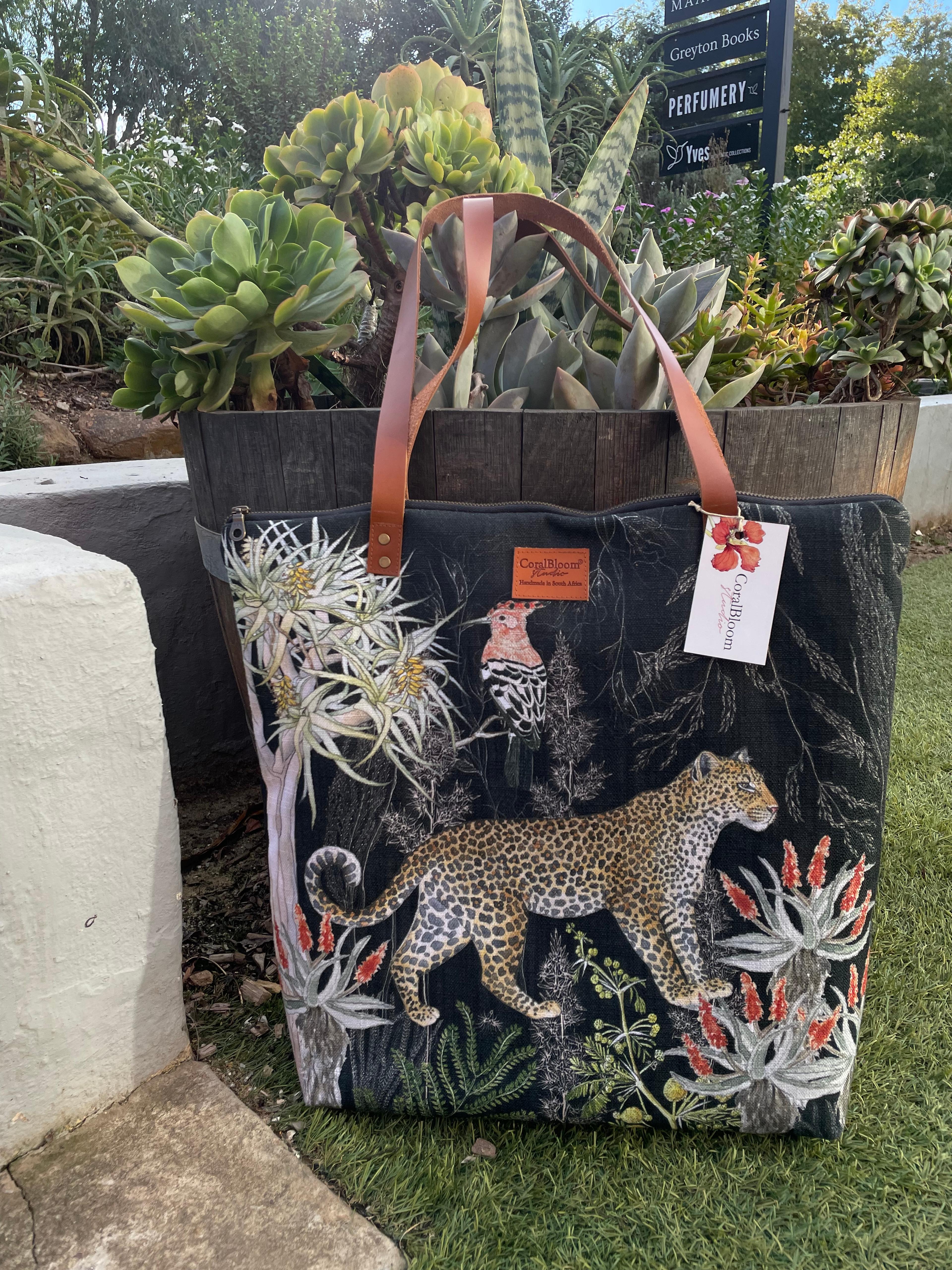 Black CoralBloom luxury tote bag printed with a watercolour leopard, white proteas and aloes