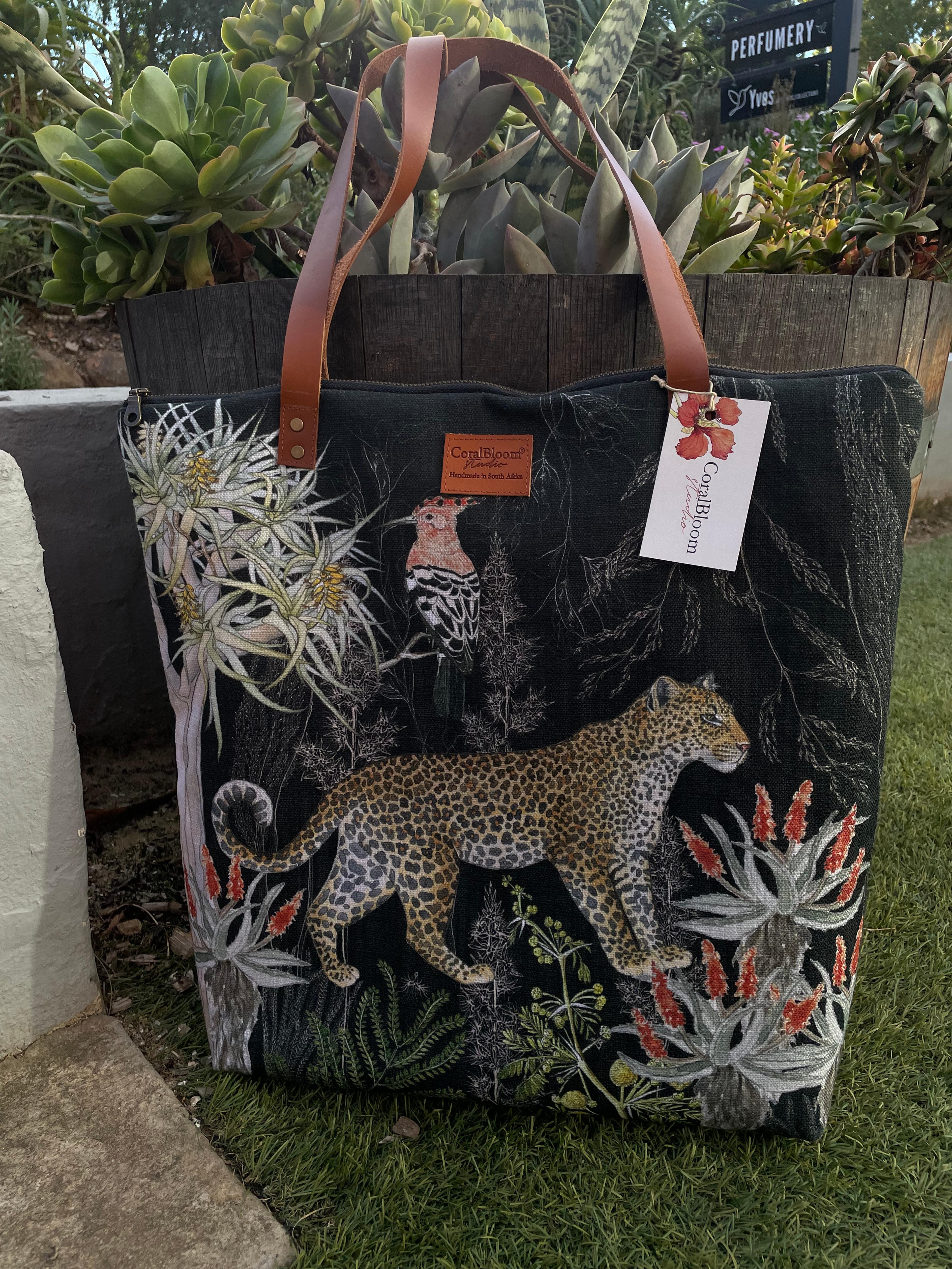 Black CoralBloom luxury tote bag printed with a watercolour leopard, white proteas and aloes