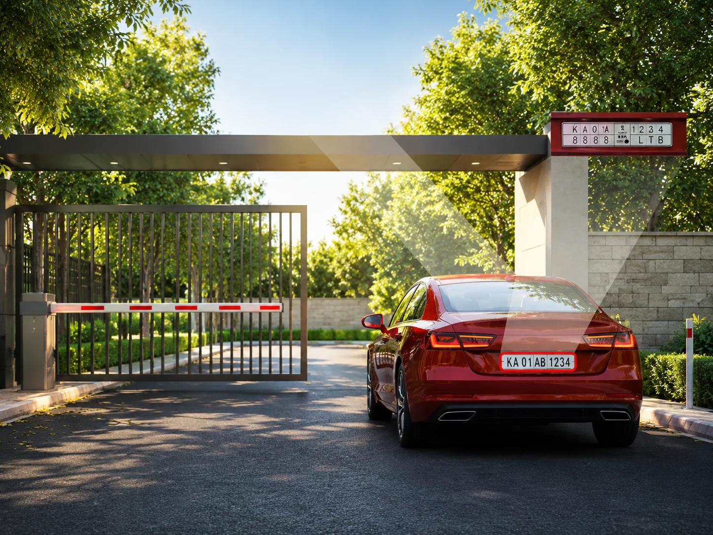 A red sedan passing through a secure gate barrier equipped with an automatic number plate recognition ANPR camera system.
