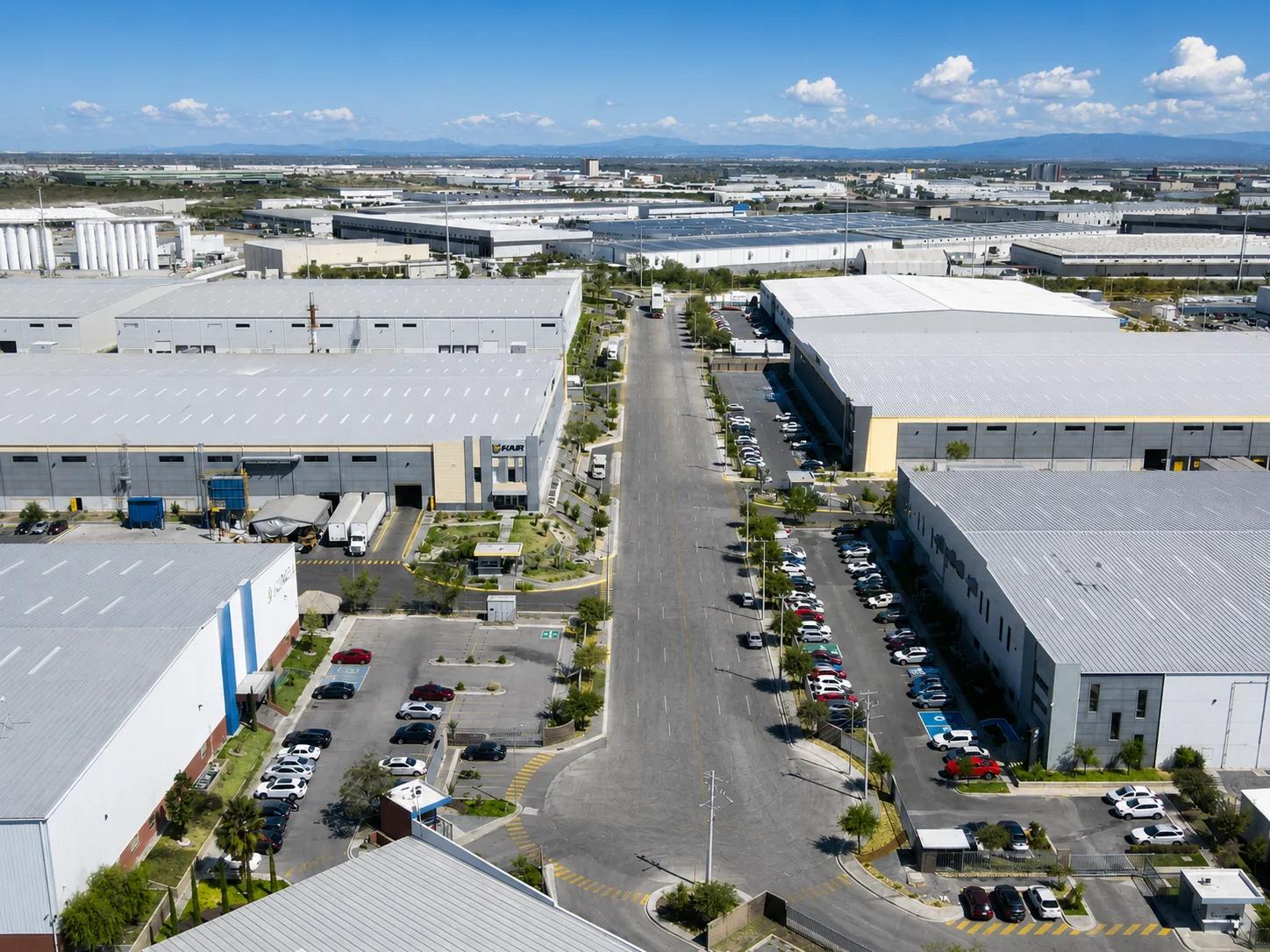 Aerial view of large logistics warehouses and parking lots using industrial video analytics to track vehicle distribution.
