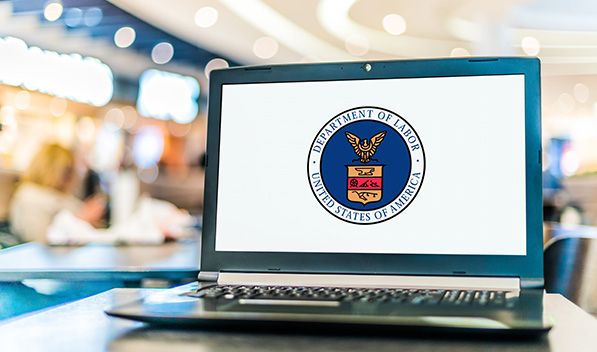 A laptop displays the U.S. Department of Labor seal on its screen.
