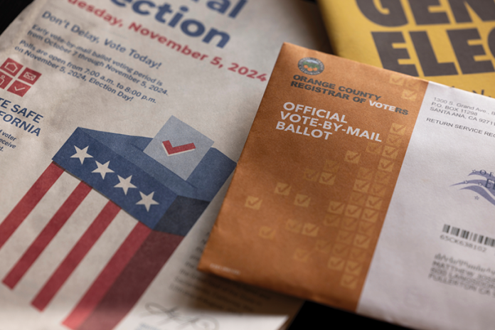 An official vote-by-mail ballot envelope rests on election materials for November 5, 2024.