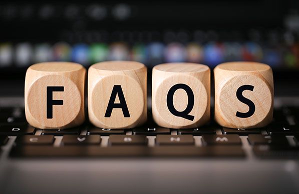 Wooden blocks spelling FAQs rest on a computer keyboard.