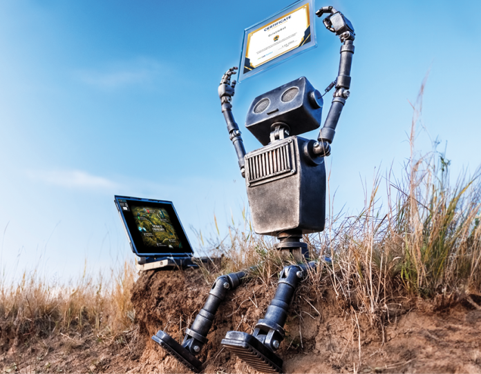 An illustrated robot raises a framed certificate while holding a laptop outdoors.