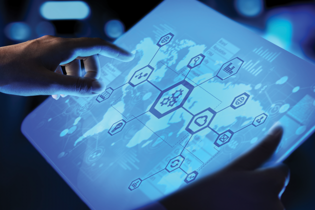 Hands interact with a glowing digital display showing a world map and connected technology icons.