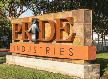 PRIDE Industries monument sign set in landscaping beside a tree.
