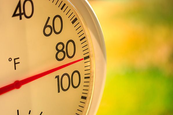 Close-up of a Fahrenheit thermometer with its red needle near 90 degrees.