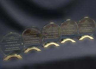 A row of rounded glass CalChamber awards displayed on gold-colored stands.