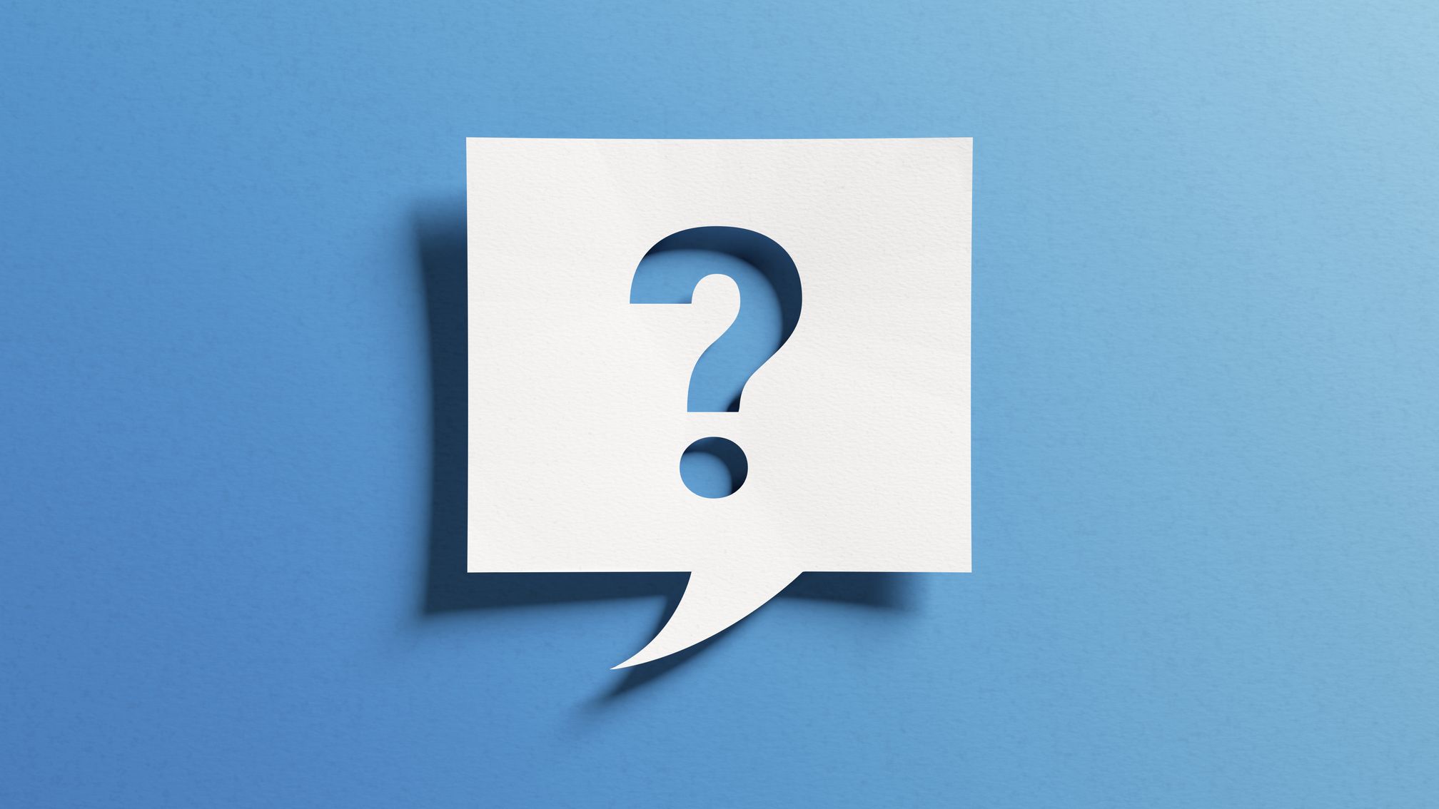 A white paper speech bubble with a question mark casts a shadow on a blue background.